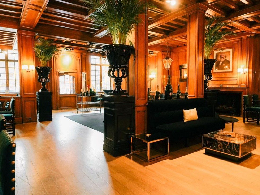 Lounge with palms and panelled walls at La Maison du Cygne